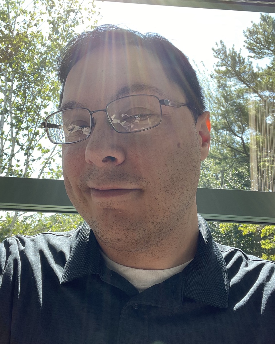 Chris Newman wearing a dark collared shirt